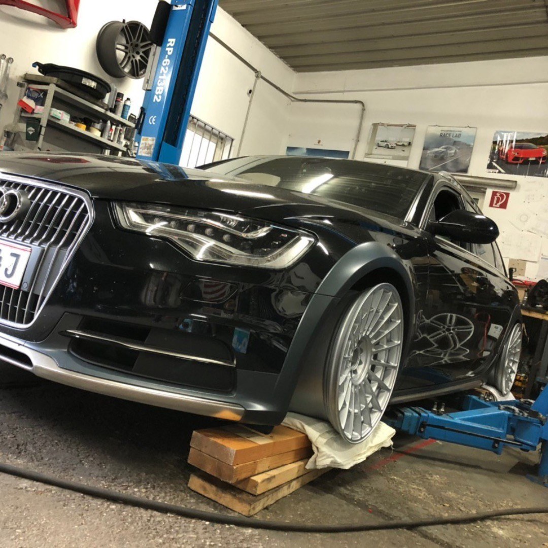 Schwarzer Audi A6 Allroad mit Rotiform-Felgen in einer Werkstatt