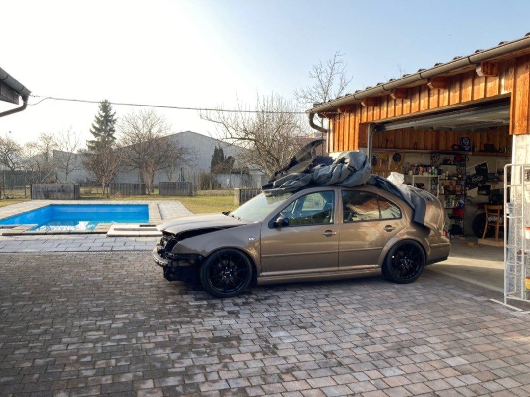 VW Bora vor einer Garage, mit Teilen auf dem Dach