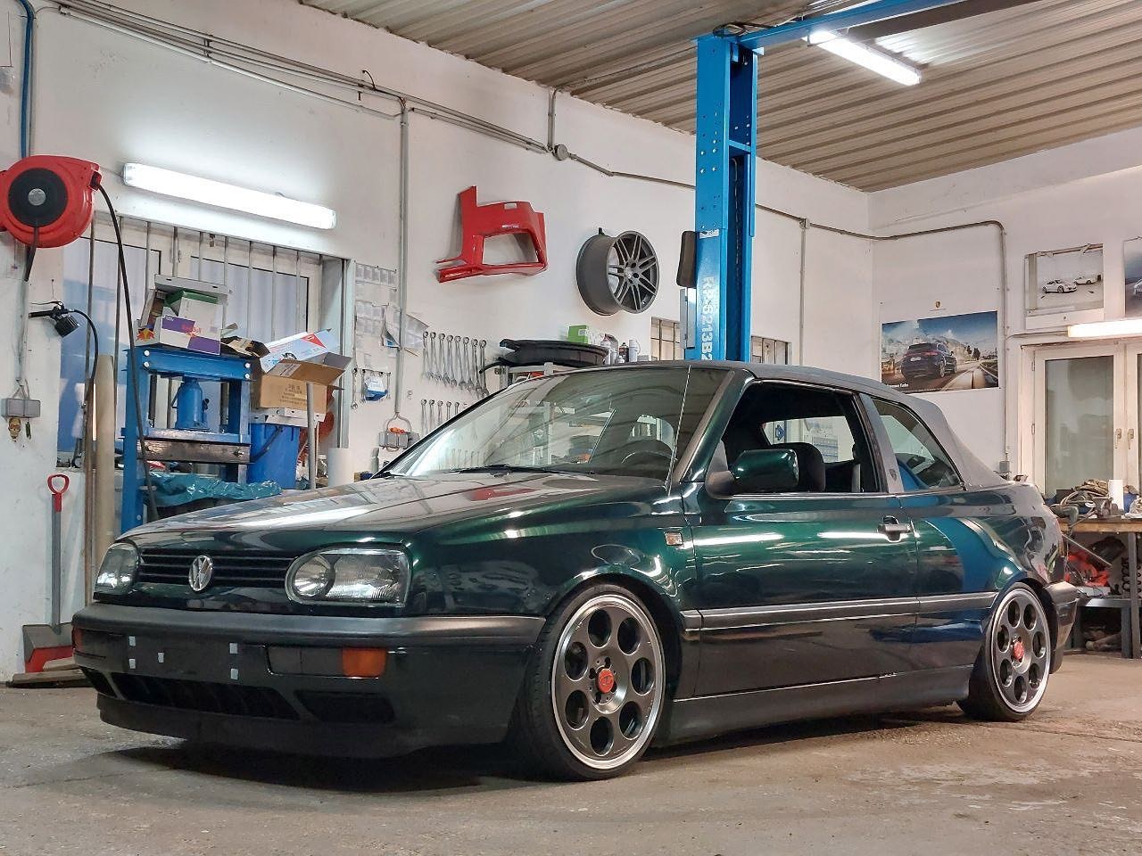 Dunkelgrünes VW Golf III Cabrio in einer Werkstatt