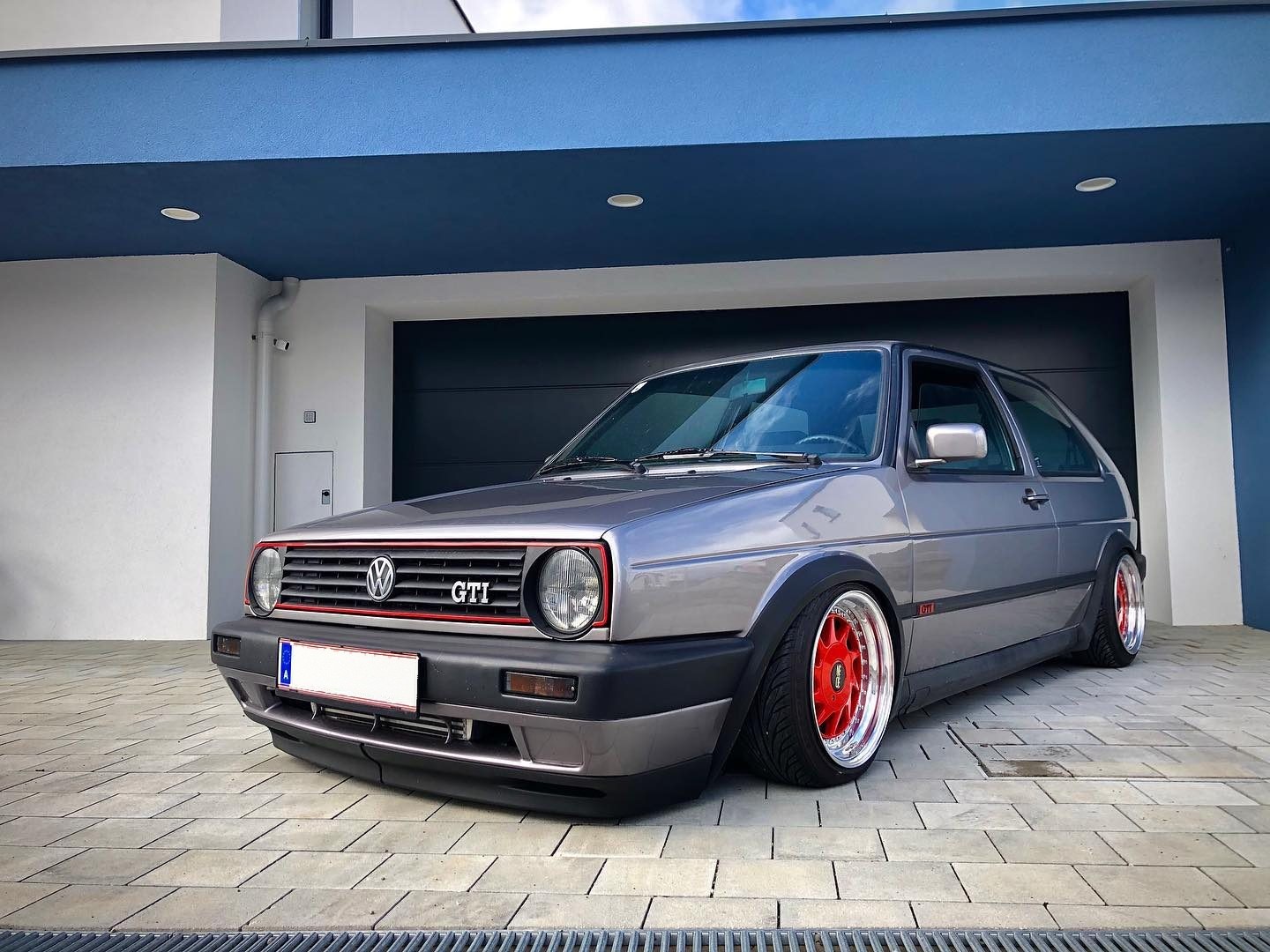 Grauer VW Golf II GTI mit roten Felgen